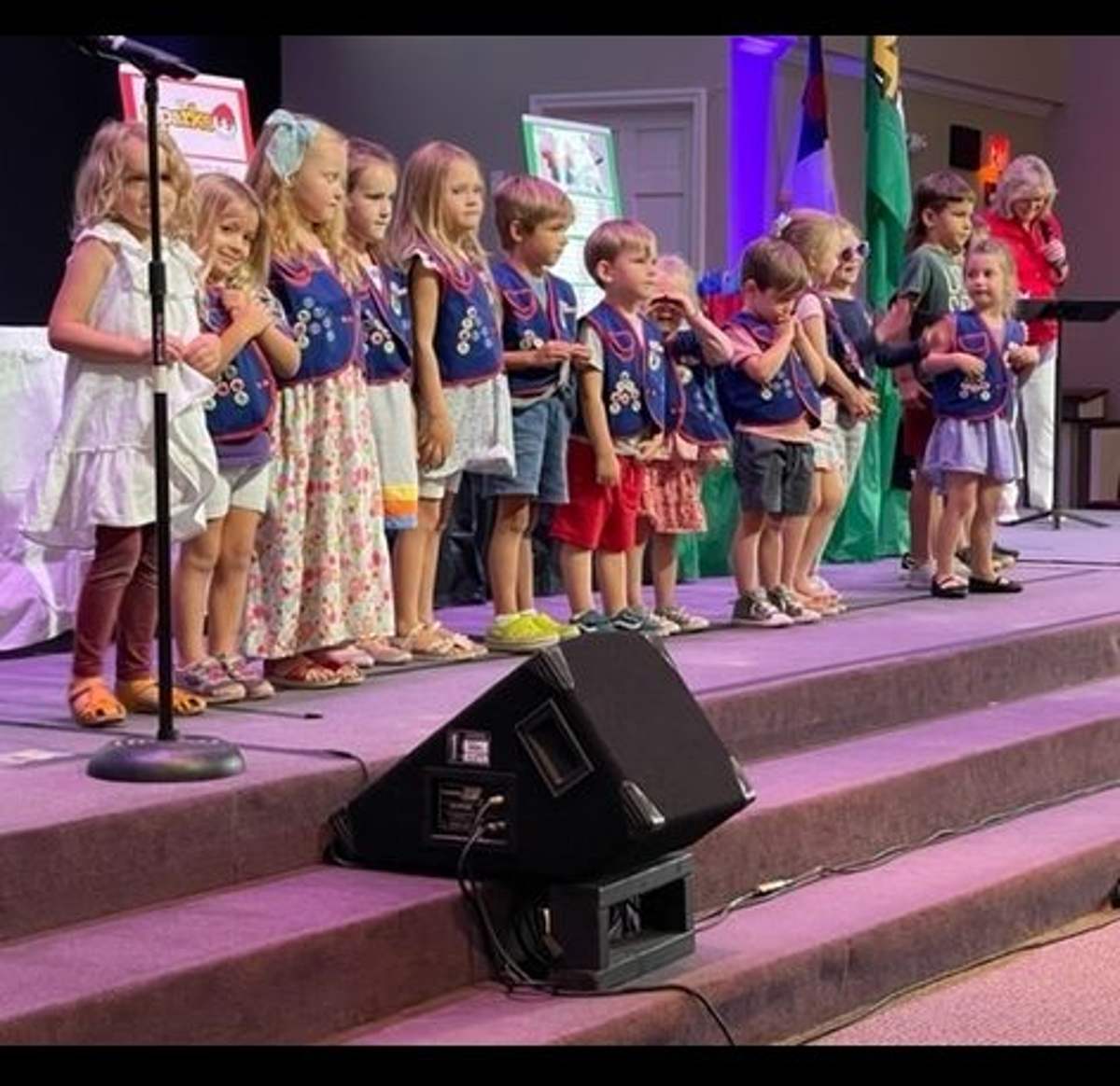 Children singing on stage during worship
